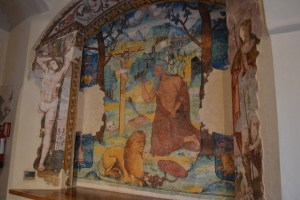 Fresco with a bearded lion at the foot of the Cross at the San Isidoro del Campo